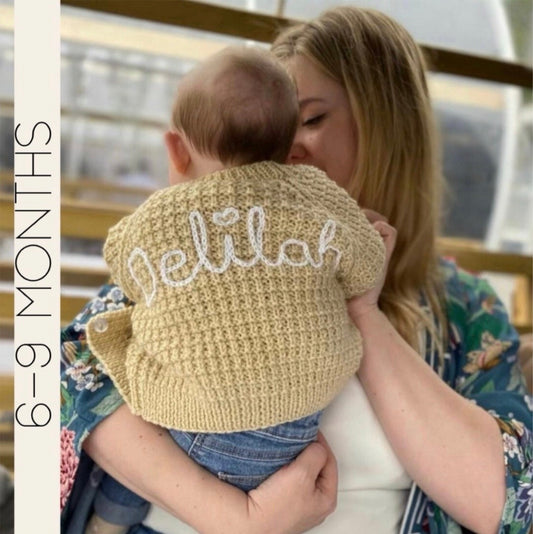Personalised hand knitted beige baby cardigan showing embroidered name, 6-9 months | Little Name Knits

