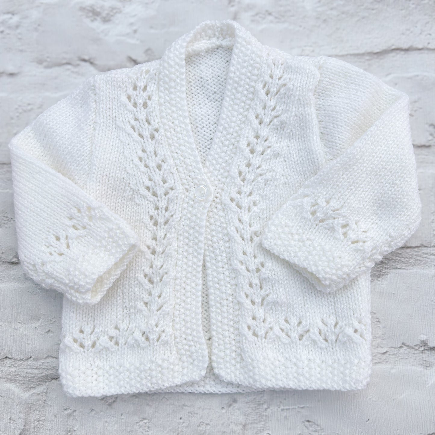 Hand knitted personalised baby cardigan in detailed white, size 0-3 months — made to order in the UK | Little Name Knits