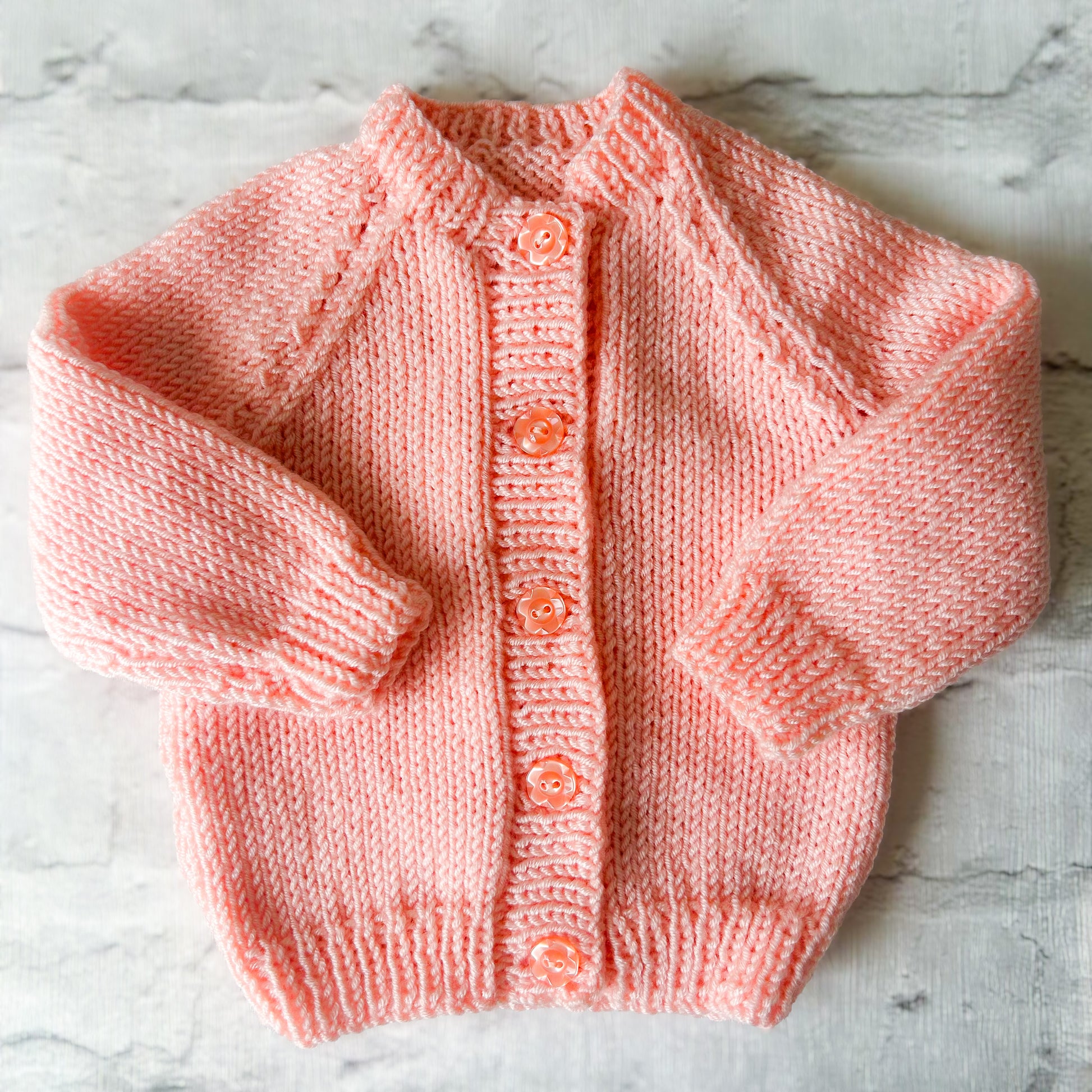 Hand knitted personalised baby cardigan in Peach size Newborn — made to order in the UK | Little Name Knits