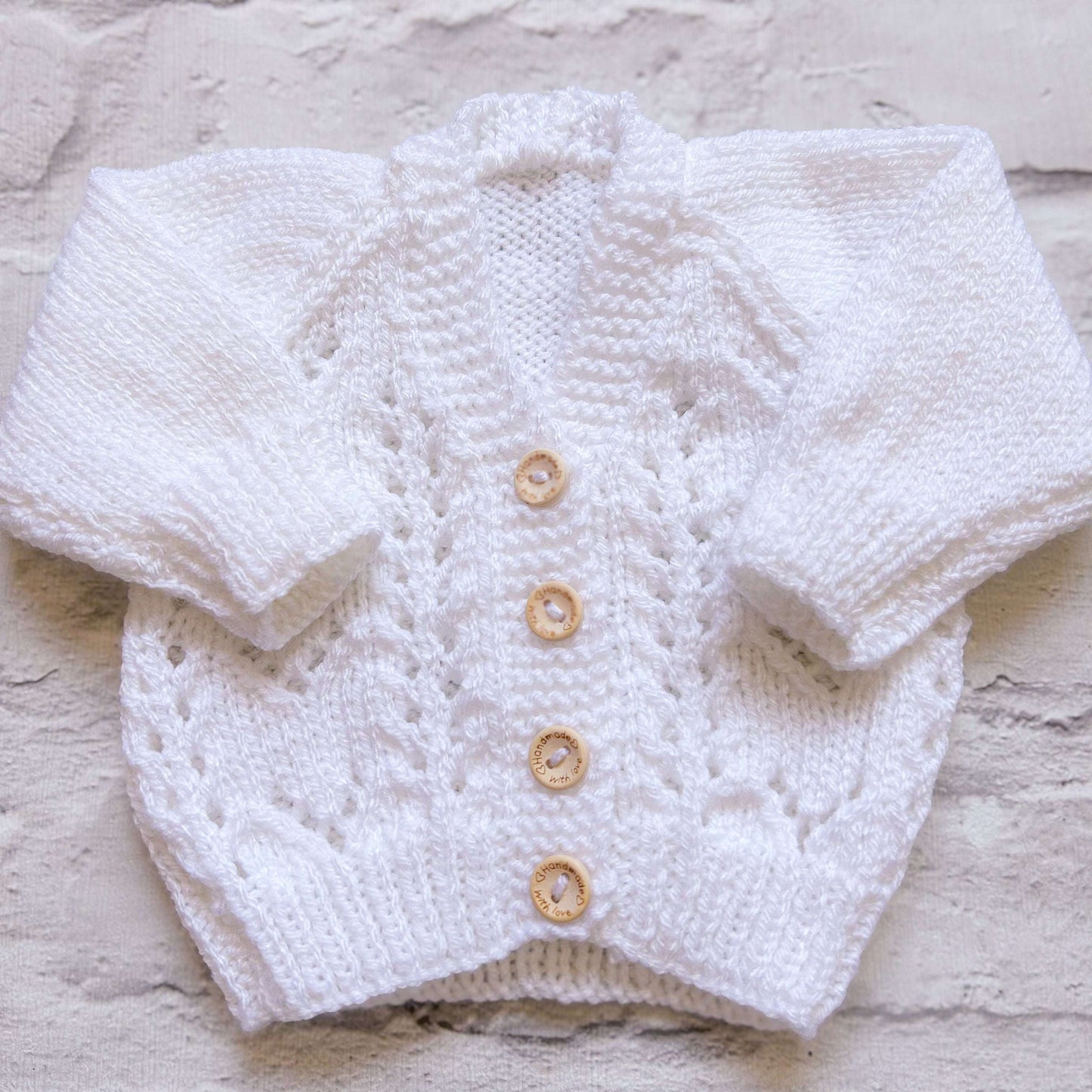 Hand knitted personalised baby cardigan in textured white, newborn size — made to order in the UK | Little Name Knits