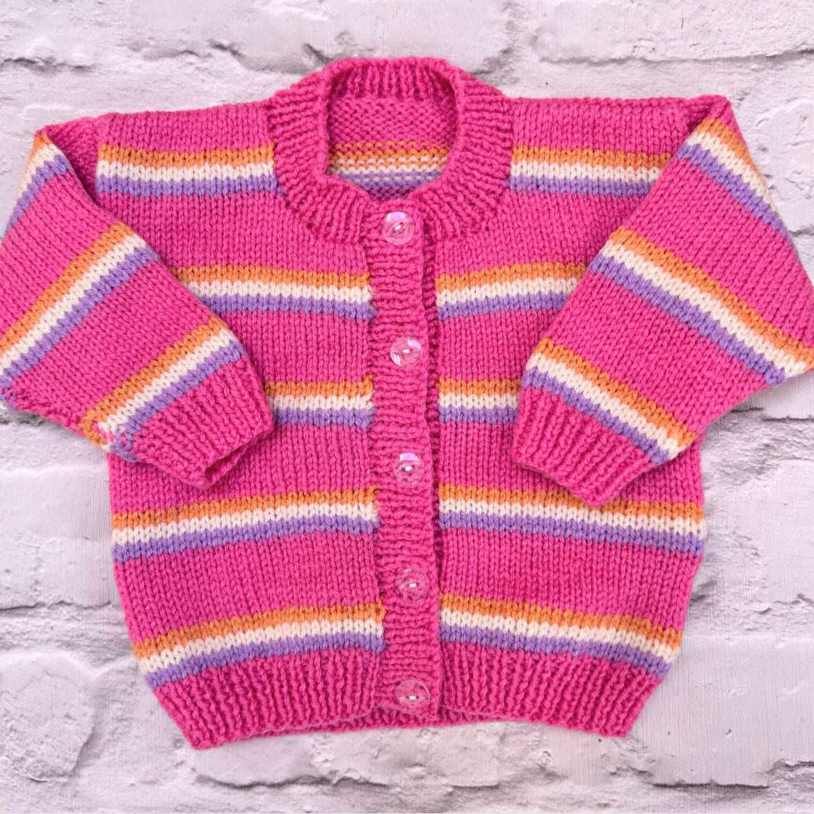 Hand knitted personalised baby cardigan in bright pink, orange, lilac stripe in size 3-6 months — made to order in the UK | Little Name Knits