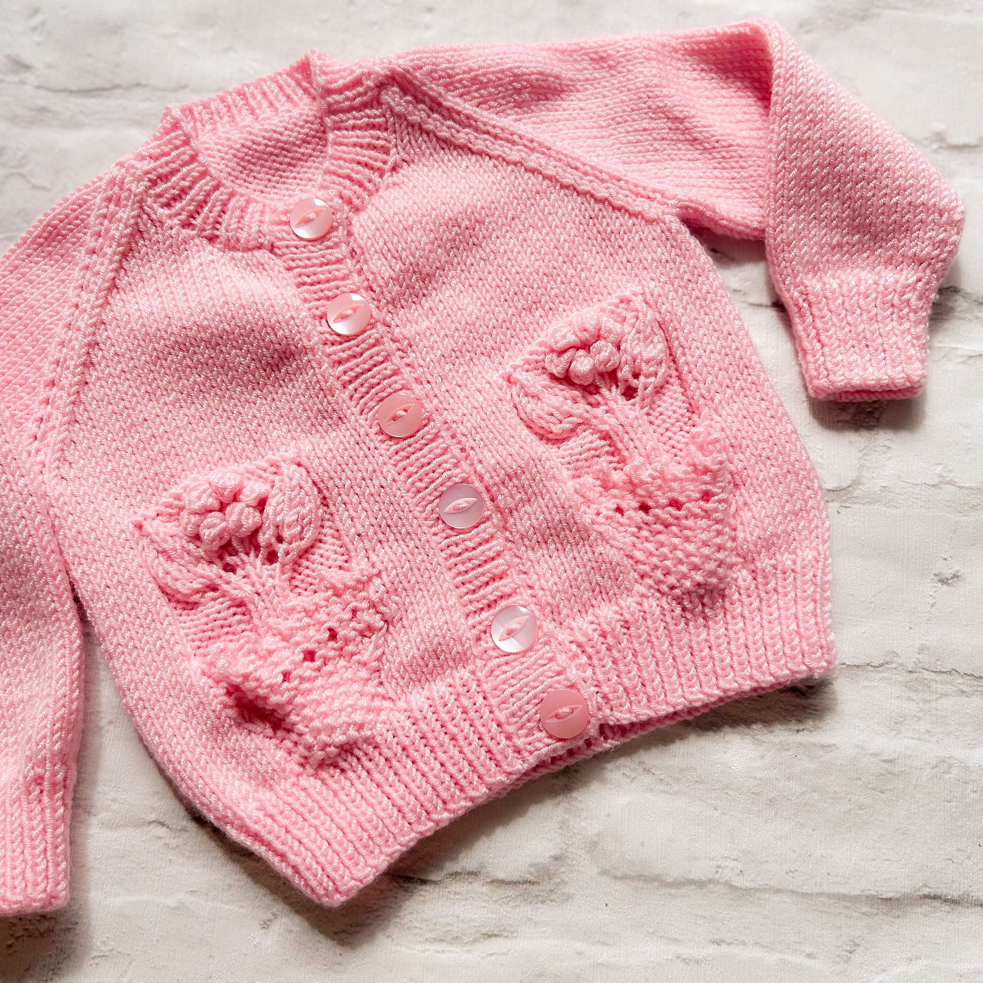 Hand knitted personalised baby cardigan in pink with flower pocket detail size 3-6 months — made to order in the UK | Little Name Knits