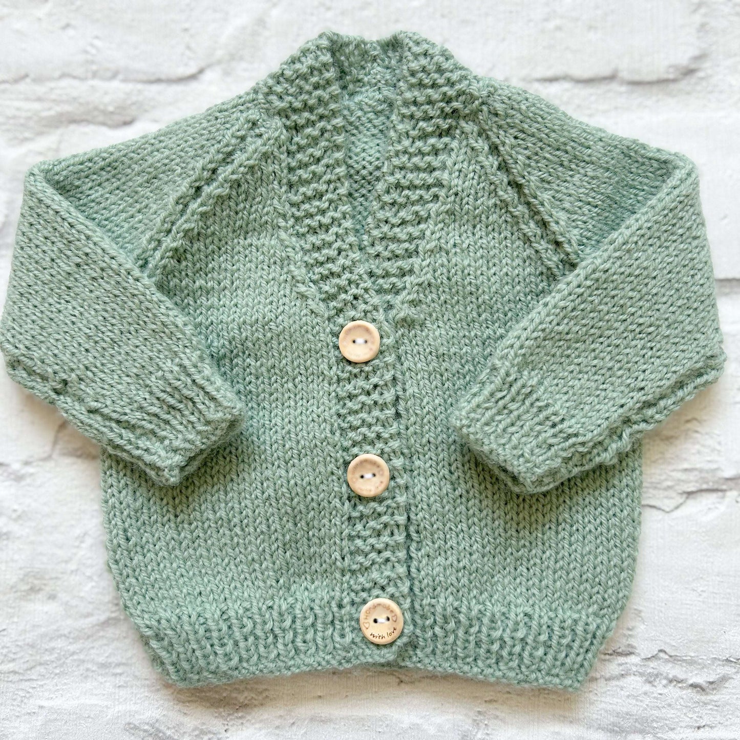 Hand knitted personalised baby cardigan in sage green, size newborn  — made to order in the UK | Little Name Knits