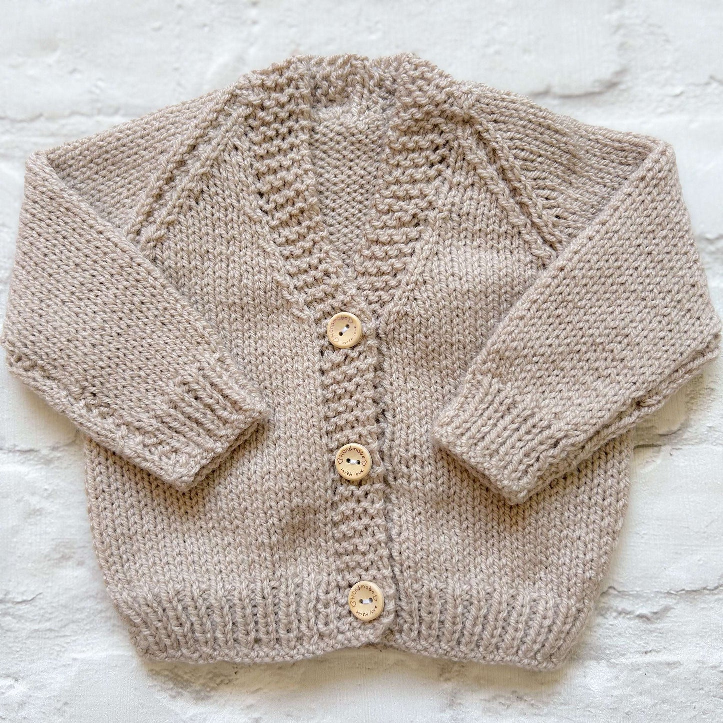 Hand knitted personalised baby cardigan in beige shade called 'latte' in size 0-3 months — made to order in the UK | Little Name Knits