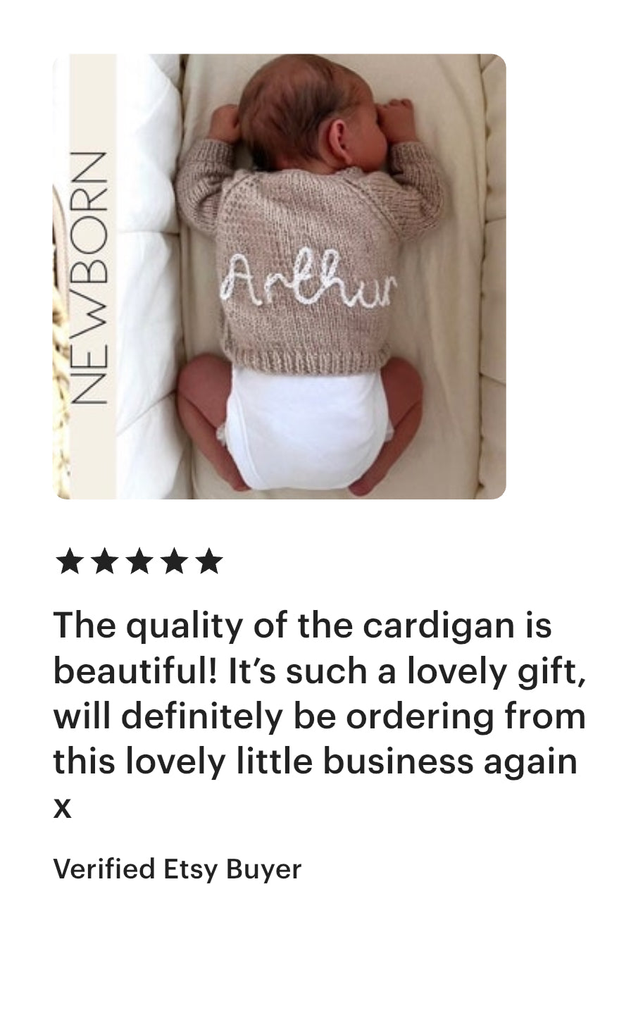 Baby wearing a hand knitted beige cardigan with name hand embroidered onto  it, lying on a white blanket in crib with a five star product review from verified etsy buyer